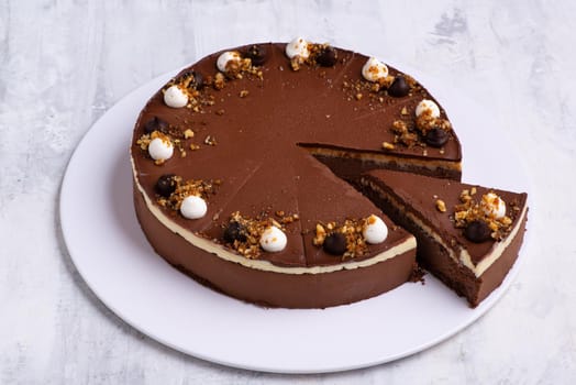 A closeup shot of a single-layered chocolate cake on a white plate