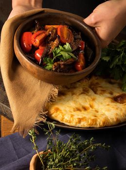 A vertical shot of a chef serving a gourmet salad dish