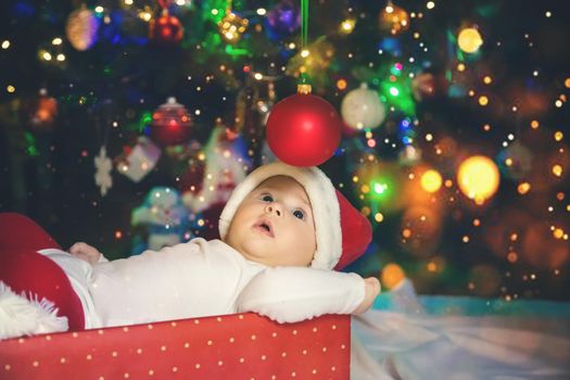 Baby is under the tree, Christmas. Selective focus. Holiday.