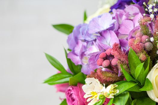 A closeup of beautiful purple lisianthus, alstroemeria, and roses in a bouquet