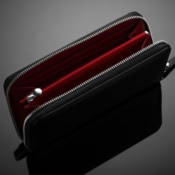 A closeup of a fashionable leather wallet on a dark background