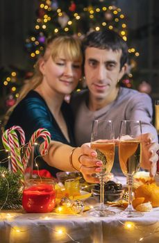 Champagne in hand against the background of the Christmas tree. People. Selective focus. Holiday.