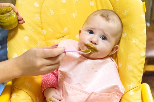 Mom feeds baby with vegetable puree. Selective focus. Food.