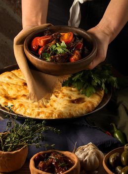 A vertical shot of a chef serving a gourmet salad dish