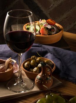 A glass of wine on a table with dishes