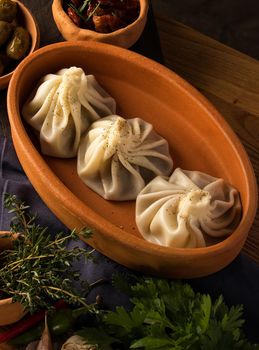 A vertical shot of a luxurious restaurant table with a gourmet khinkali dish