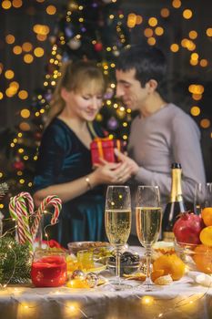 Champagne in hand against the background of the Christmas tree. People. Selective focus. Holiday.