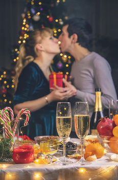 Champagne in hand against the background of the Christmas tree. People. Selective focus. Holiday.