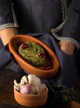 A vertical shot of a waitress presenting a pkhali