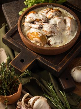 A vertical shot of a chicken covered in a creamy sauce