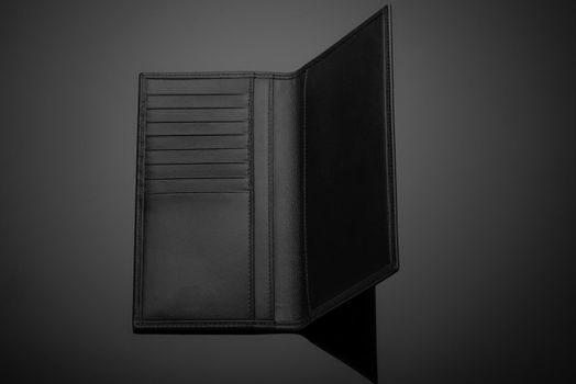 A closeup of a fashionable leather men's wallet on a dark background