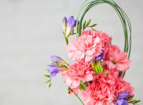 A closeup of a beautiful composition with pink spray carnations and freesia isolated on a white background