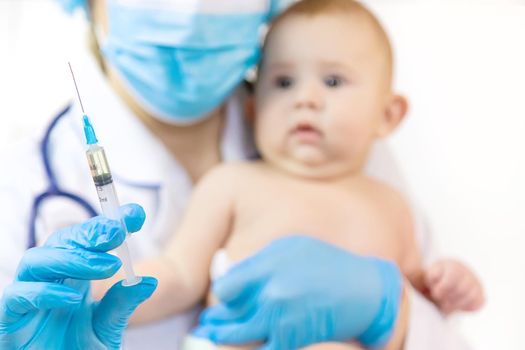 Vaccination of a baby by a doctor in a hospital. Selective focus. medicine.