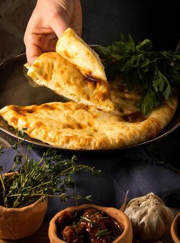 A vertical shot of a chef serving a gourmet Georgian dish