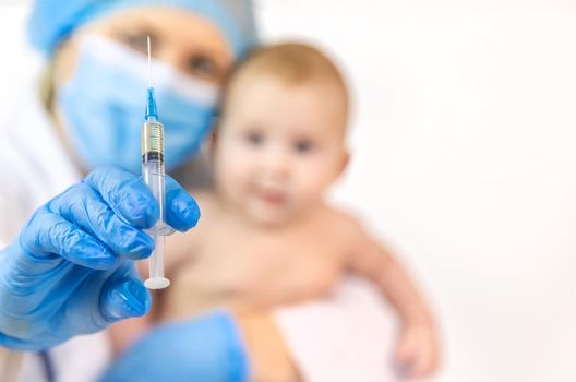 Vaccination of a baby by a doctor in a hospital. Selective focus. medicine.