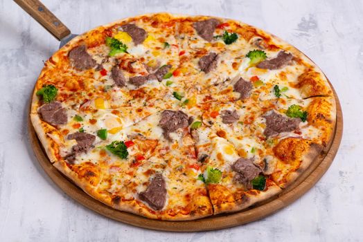 A closeup shot of a freshly baked pizza on a round tray