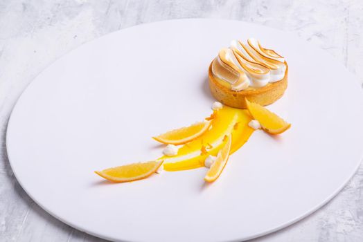 The appetizing lemon tartlets with meringue served on a white plate