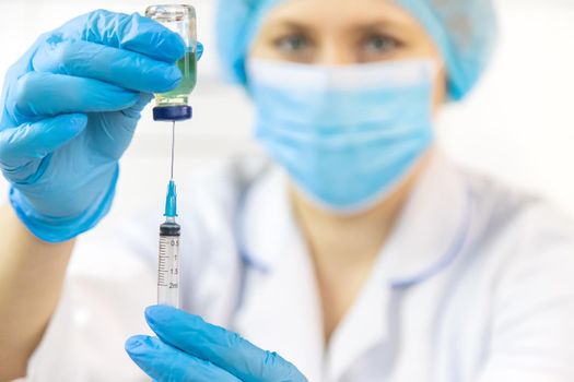 Doctor filling syringe with medication, closeup. Vaccination and immunization. Selective focus. Vaccine.