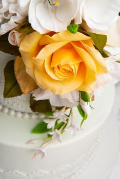 A close up shot of designed rose flowers on a white cake.