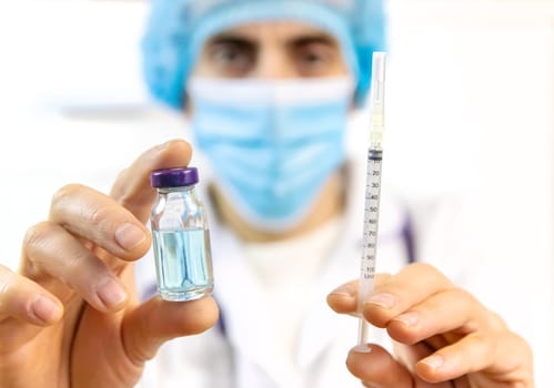 Doctor filling syringe with medication, closeup. Vaccination and immunization. Selective focus. Vaccine.