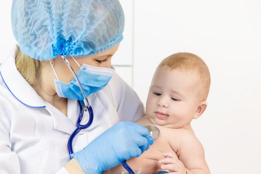 The doctor listens to the baby with a stethoscope. Selective focus. People.