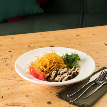 A closeup of a delicious dish with shredded potatoes, beef, sauce and sandwiches