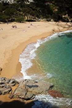 Costa Brava beach with turquoise water on sunny day.