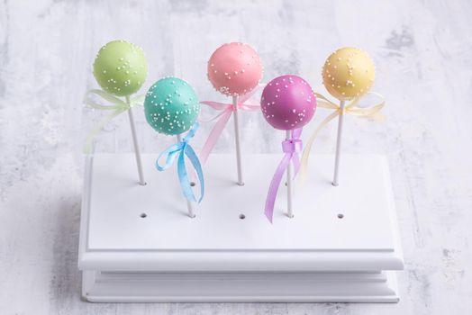 Colorful cake pops on a textured background