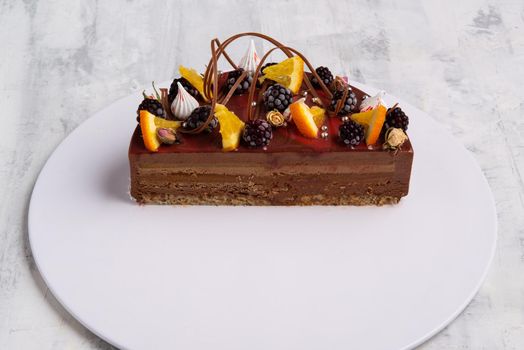 A closeup shot of a tasty cake topped with candies and fresh fruits