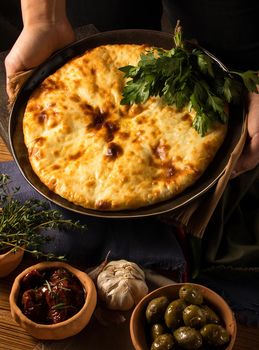 A vertical shot of a chef serving a gourmet Georgian dish