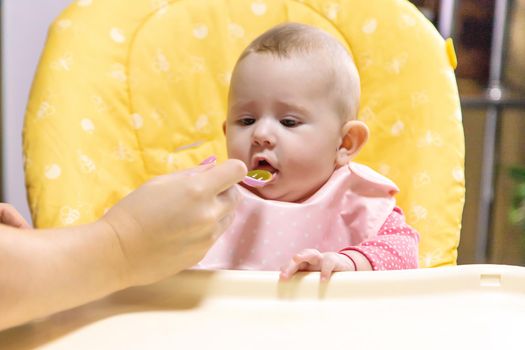 Mom feeds baby with vegetable puree. Selective focus. Food.
