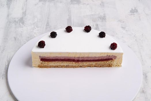 A closeup shot of white-layered cake topped with fresh berries