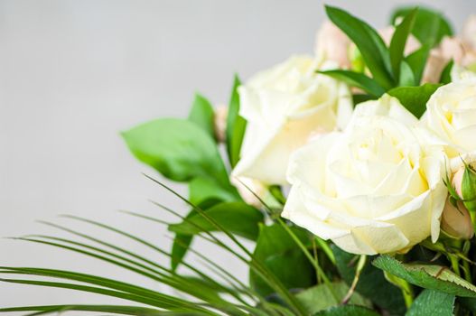 A closeup of beautiful white roses and green leaves in a bouquet