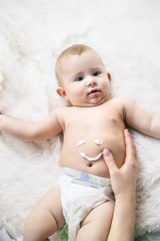 mother puts cream on little baby. Selective focus. Child.