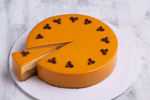 A closeup shot of tasty yellow layered cake topped with roasted coffee beans