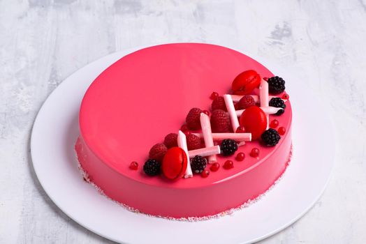 A closeup shot of a tasty cake topped with candies and fresh fruits