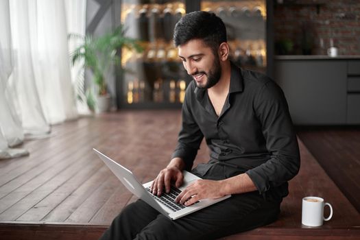 happy business owner using a laptop in his new cafe. concept of wireless technologies.