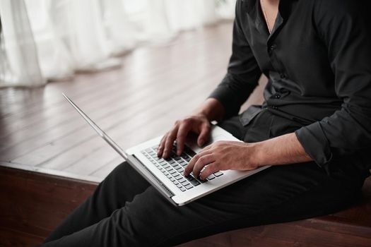 close-up. cropped image of a businessman with a laptop sitting on the floor. startup concept.
