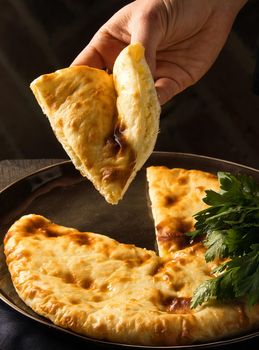 A vertical shot of a chef serving a gourmet Georgian dish