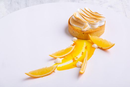 The appetizing lemon tartlets with meringue served on a white plate