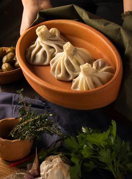 A vertical shot of a luxurious restaurant table with a gourmet khinkali dish