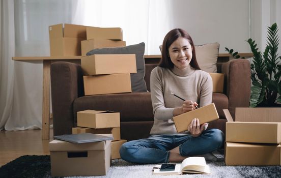 Portrait of Starting small businesses SME owners female entrepreneurs working on receipt box and check online orders to prepare to pack the boxes, sell to customers, sme business ideas online..