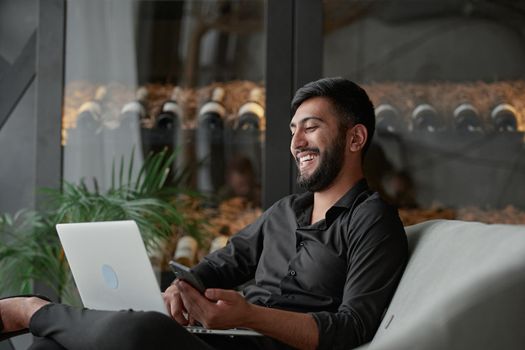 business man with a smartphone and laptop sitting in an armchair . close-up.