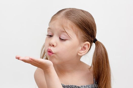Caucasian little girl of 6 years blowing on palm as breathing exercise in speech therapy. Concept dysarthria, logopedics