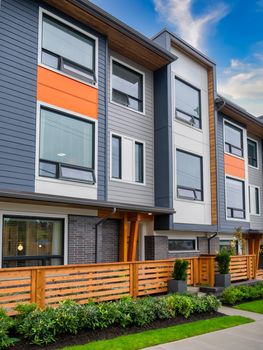 Brand new townhouses for sale. Row of new townhomes on blue sky background.