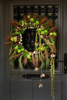 Wreath with apples and cotton hanging on a door.