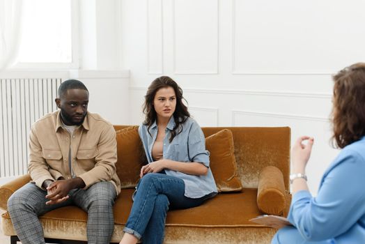 Diverse couple talking to psychologist woman about relationship problems. Marital Therapy. Family Reconciliation