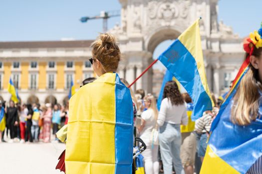 Portugal, Lisbon April 2022: The demonstration on Commerce Square in support of Ukraine and against the Russian aggression. Protesters against Russia's war Many people with Ukrainian flags. Crowd