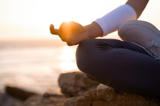Woman practice yoga lotus pose to meditation with summer vacation rocky beach happiness and relaxation. Calm female exercise with yoga meditate ocean beach with sunset golden time. Zen Mental health