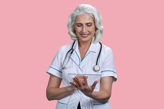 Smiling medical doctor woman working on transparent futuristic tablet pc. Future innovation concept.